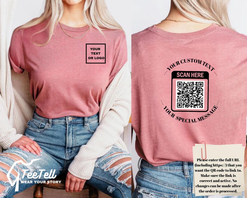 May include: A dusty rose t-shirt with a square box that says "YOUR TEXT OR LOGO" on the front. The back of the shirt has a QR code with the text "YOUR CUSTOM TEXT SCAN HERE YOUR SPECIAL MESSAGE". The shirt is paired with blue jeans.