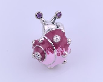 May include: A snail-shaped charm with a silver-tone body and a shell in shades of pink and burgundy. The snail's eyes are purple, and the shell has silver-tone accents. The charm is likely made of metal and is designed to be a decorative accessory.