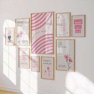 Pu&ograve; includere: Una collezione di stampe artistiche incorniciate di varie dimensioni, disposte su una parete bianca. Le stampe presentano disegni rosa e bianchi, illustrazioni floreali e citazioni ispiratrici. La stampa pi&ugrave; grande recita "PROTECT YOUR PEACE."