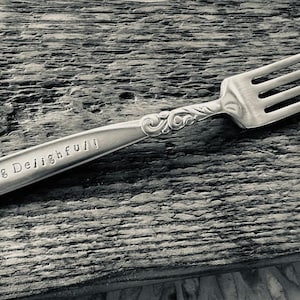 Könnte beinhalten: Eine silberne Gabel mit einem verzierten Griff und den Worten "I'm Forking Delightful!" eingraviert auf dem Griff.