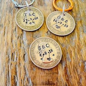 May include: Three gold-colored coins with a profile of Queen Elizabeth II on each. The coins have been personalized with initials and dates, such as "T & C 27.9.04", "G & S 16.7.23", and "S & C 4.8.18".