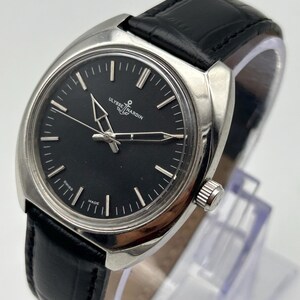 intage Ulysse Nardin manual wind watch with black dial and leather strap