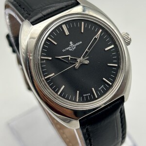intage Ulysse Nardin manual wind watch with black dial and leather strap