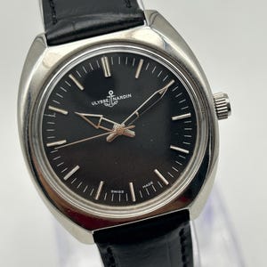 intage Ulysse Nardin manual wind watch with black dial and leather strap