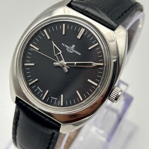 intage Ulysse Nardin manual wind watch with black dial and leather strap
