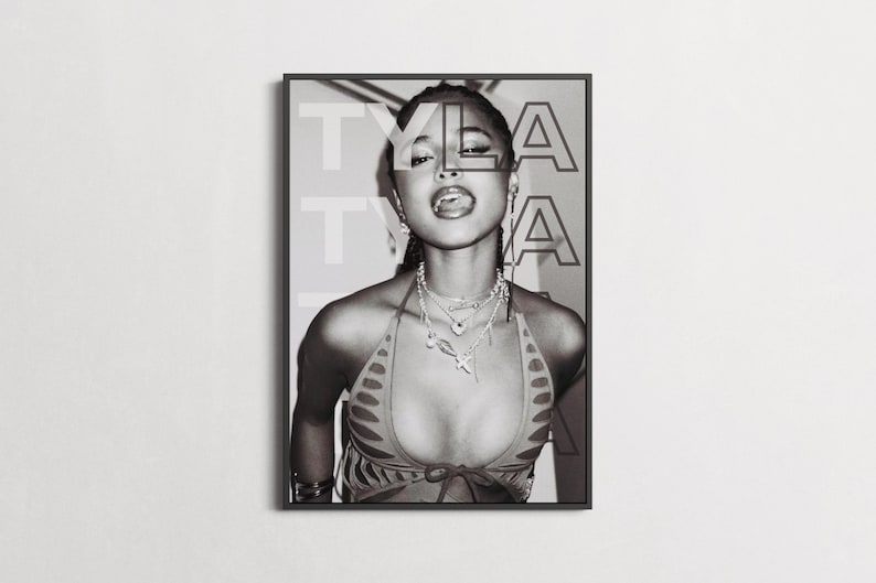 May include: Black and white framed portrait of a person with the name "TYLA" overlaid. The person is wearing a halter top and multiple necklaces. The person is sticking out their tongue.