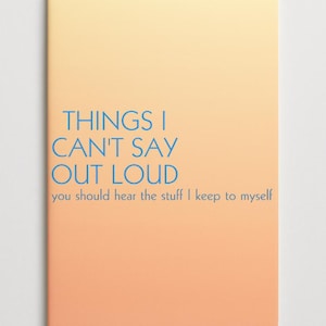 Può includere: Un taccuino con una copertina sfumata pesca e gialla. Il testo blu recita "THINGS I CAN'T SAY OUT LOUD" con il testo più piccolo "you should hear the stuff I keep to myself" sotto. Il taccuino ha angoli arrotondati.