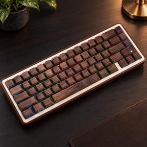 Op de afbeelding: Een mechanisch toetsenbord met donkerbruine houten toetsen met een zichtbare houtnerf en een bijpassend houten frame. Het toetsenbord heeft een compacte indeling met zichtbare RGB-achtergrondverlichting tussen de toetsen. De spatiebalk is van hout.