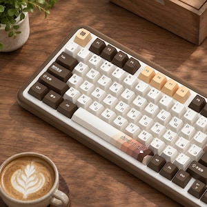 May include: A mechanical keyboard with a brown frame and a color scheme of white, dark brown, and light tan keycaps. The keys feature alphanumeric characters, Cyrillic letters, and Chinese text. The spacebar displays the Chinese text 咖啡时光.