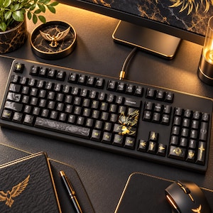 May include: A black mechanical computer keyboard featuring gold eagle graphics on the spacebar, arrow keys, and specific letter keys. The keys have a dark finish with gold-colored symbols and characters, and the keyboard is connected via a black cable.