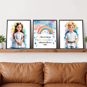 May include: Three framed watercolor art prints featuring children and a rainbow. The first print shows a girl in a blue dress, the second a rainbow with text, and the third a boy in a white shirt. The prints are displayed on a wooden shelf.