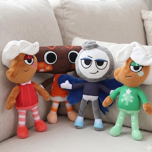 May include: Four plush dolls featuring cartoon characters. Two dolls have brown skin, white hair, and festive outfits. One doll is brown with large circular eyes and orange accents. One doll is gray with blue wings, a dark blue shirt, and light blue boots.