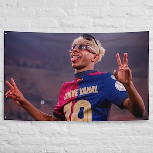 May include: A wall tapestry featuring a person wearing sunglasses and a soccer jersey with the name "AMINE YAMAL" and the number "10". The person is making a peace sign with both hands and sticking out their tongue. The jersey is red and blue.