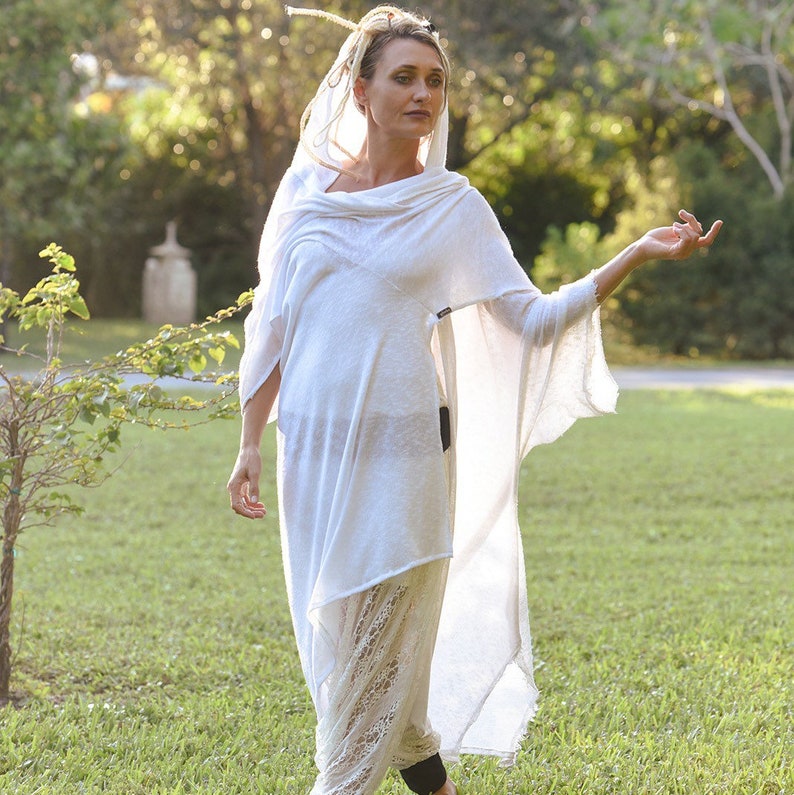 May include: A white, flowing, lightweight, sheer,  long tunic with a cowl neck and a long, flowing train. The tunic is made of a soft, breathable fabric and is perfect for layering.