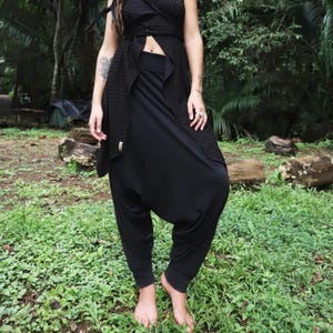 May include: Black harem pants with a loose, flowing fit. The pants are made of a soft, comfortable fabric and have a wide, elastic waistband.