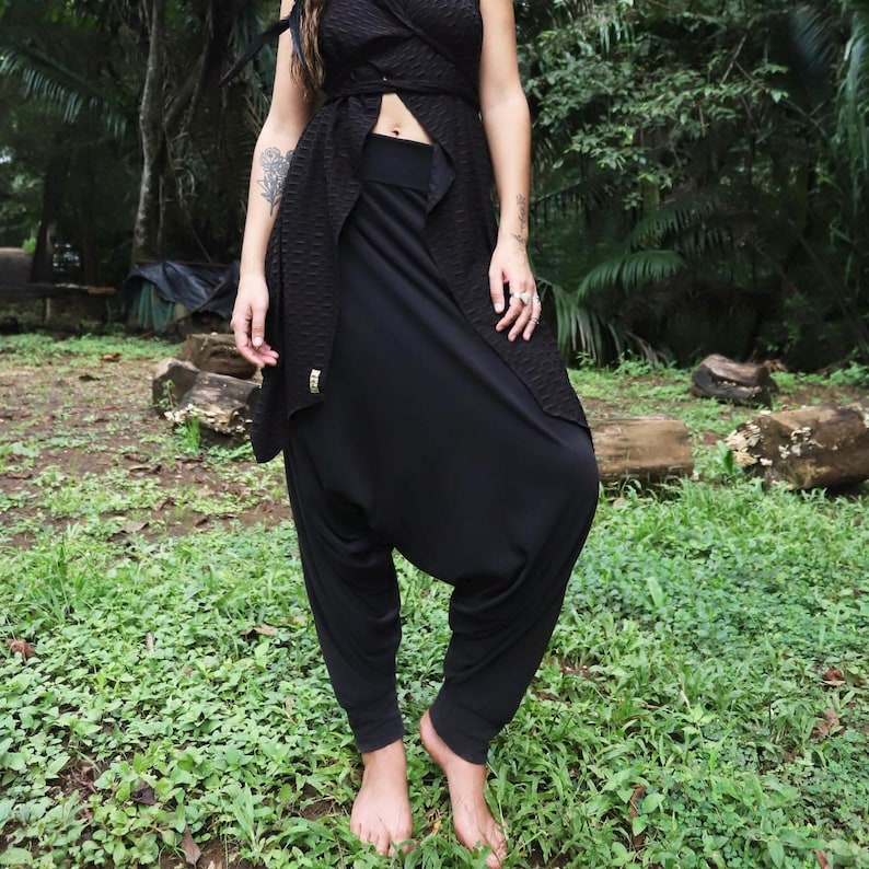 May include: Black harem pants with a loose, flowing fit. The pants are made of a soft, comfortable fabric and have a wide, elastic waistband.