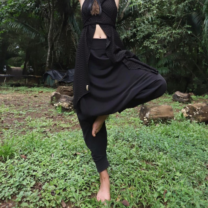 May include: Black harem pants with a wide waistband and a loose, flowing fit. The pants are made of a soft, comfortable fabric and are perfect for yoga, dance, or everyday wear.