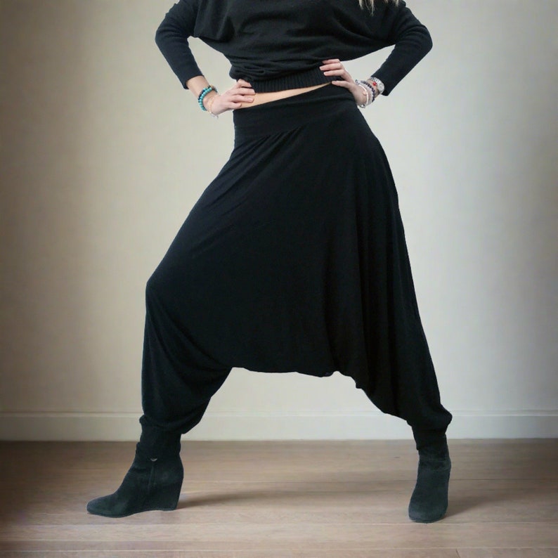 Puede incluir: Pantalones de har&eacute;n negros con pierna ancha y corte holgado. Los pantalones est&aacute;n hechos de una tela suave y el&aacute;stica y tienen una cintura c&oacute;moda.