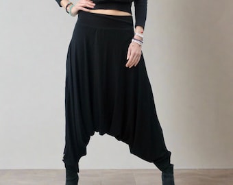 Puede incluir: Pantalones de harén negros con pierna ancha y cintura elástica.