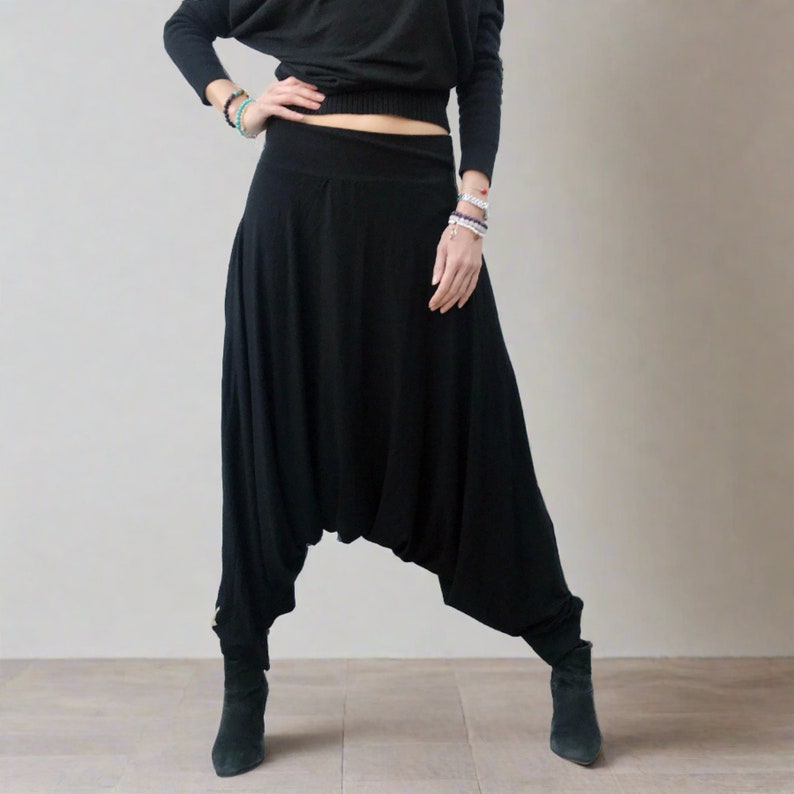 Puede incluir: Pantalones de har&eacute;n negros con pierna ancha y cintura el&aacute;stica.