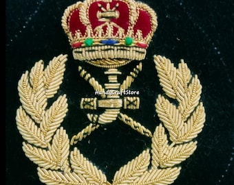 May include: Embroidered emblem featuring a red and gold crown above crossed swords and a gold wreath. The emblem is intricately detailed with gold thread and colorful accents, set against a black background. The text "HandyCraftStore" is visible.