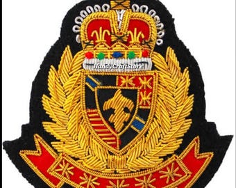 May include: Embroidered patch featuring a gold crown, shield, and banner on a black background. The shield has a gold emblem and red, blue, and gold accents. The banner is red with gold stars. The text "HandyCraftStore" is visible.