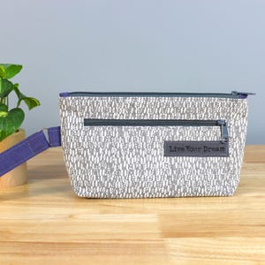 Bolsa de pulso com zíper estampada em cinza e branco reciclada com bolso com zíper