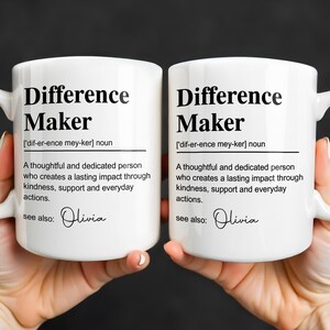 May include: Two white ceramic mugs featuring black printed text that defines the term Difference Maker as a thoughtful and dedicated person who creates a lasting impact through kindness, support and everyday actions, with the name Olivia listed below.