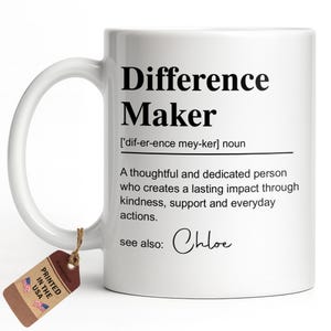 May include: A white ceramic mug featuring black text that defines the term Difference Maker as a thoughtful and dedicated person who creates a lasting impact through kindness, support and everyday actions, with the name Chloe listed under see also.