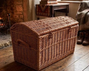 May include: A rectangular storage chest crafted from woven light brown wicker. The chest features a domed, hinged lid with two woven loops for closure and integrated side handles. The construction consists of tightly woven natural willow reeds.