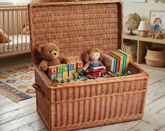 May include: A large rectangular woven wicker storage chest with an open hinged lid. The interior contains a brown teddy bear, a doll with yarn hair, a red toy fire truck, several colorful alphabet blocks, and a row of upright children's books.