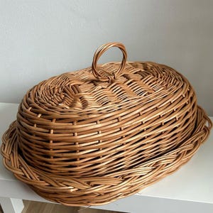 Puede incluir: Cesta ovalada de mimbre con tapa y asa. La cesta de mimbre marr&oacute;n claro tiene una tapa a juego con un asa en forma de bucle. La cesta est&aacute; dise&ntilde;ada para almacenamiento o exhibici&oacute;n.