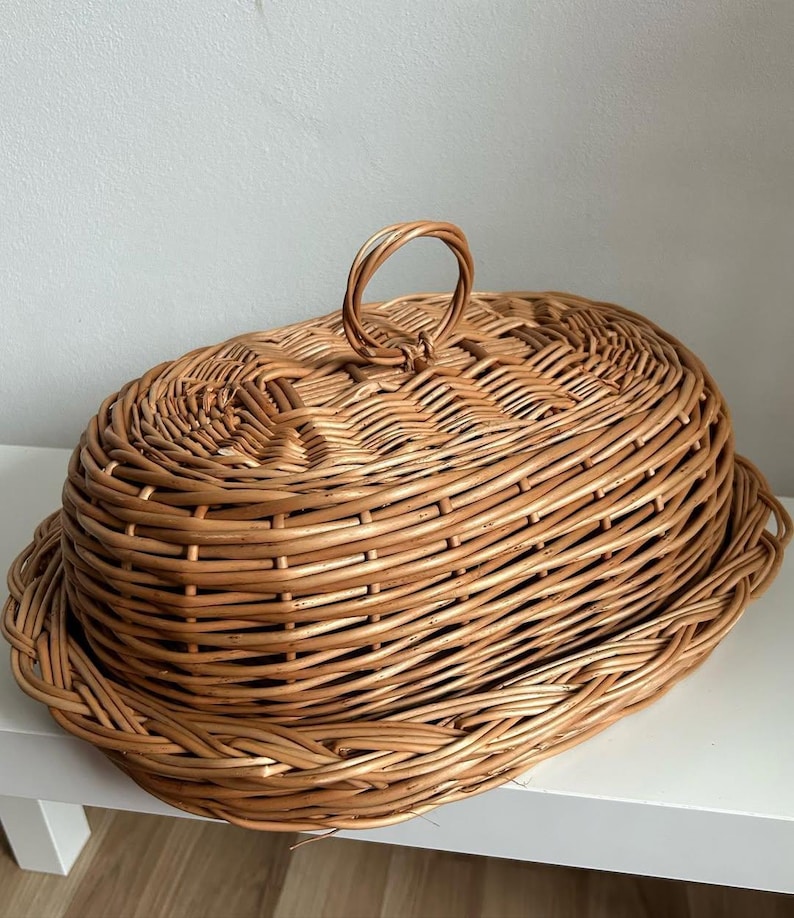 Puede incluir: Cesta ovalada de mimbre con tapa y asa. La cesta de mimbre marr&oacute;n claro tiene una tapa a juego con un asa en forma de bucle. La cesta est&aacute; dise&ntilde;ada para almacenamiento o exhibici&oacute;n.