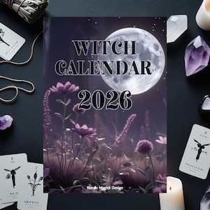 Puede incluir: Un "Witch Calendar 2026" con un fondo de luna llena, flores moradas y el texto "Nordic Magick Design". La imagen está rodeada de cartas del tarot, cristales y una vela encendida, creando un tema místico.