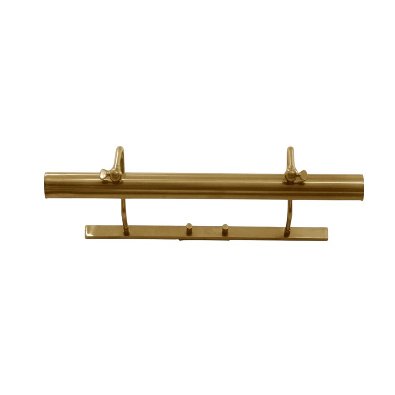 May include: A brass-colored picture light with a cylindrical body and a rectangular base. The light has two adjustable arms and two small knobs. The fixture is designed to illuminate artwork or photographs.