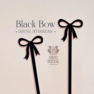 May include: Two black bow-shaped drink stirrers against a light pink background. The text "Black Bow - DRINK STIRRERS" is at the top. The logo for Simply Social is at the bottom right.