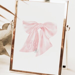 May include: A pink watercolor bow with a monogram of the letters "WFC" in the center.