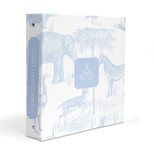 May include: A light blue binder with a white background and a pattern of blue animals, including an elephant, zebra, and deer. The binder has a spine with the text "LINCOLN JAMES ANDERSON." and a blue monogrammed initial "A" on the front.