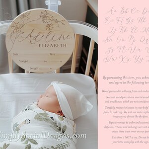 May include: A wooden round sign with a floral design and the name "Adeline Elizabeth" written in cursive. The sign has spaces to fill in the date, time, weight, and length. The sign is hanging on a crib with a baby sleeping inside.
