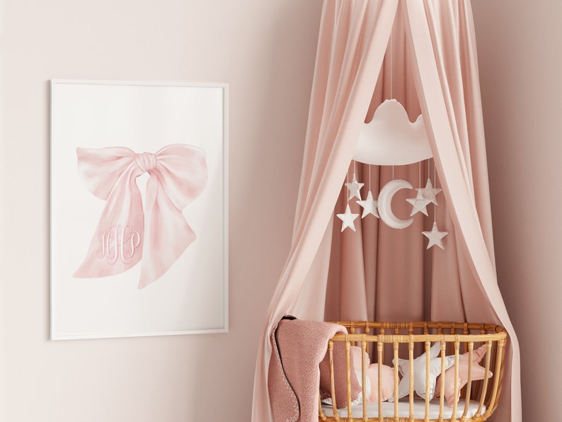 May include: A pink and white baby crib canopy with a white cloud mobile hanging above it. The mobile has a crescent moon and stars. The crib is made of wicker and has a pink blanket inside.