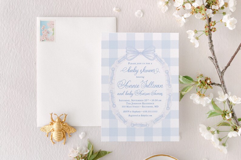 May include: A blue and white gingham baby shower invitation with a blue ribbon and a lace design. The invitation reads "Please join us for a baby shower honoring Annie Sullivan and baby Carson James".