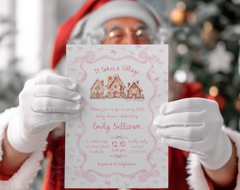 Op de afbeelding: Een uitnodiging voor een babyshower, vastgehouden door een persoon in een kerstman kostuum. De uitnodiging bevat de tekst "It takes a Village" en details voor Emily Sullivans babyshower, met een roze strik ontwerp.