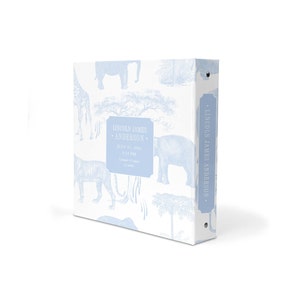 May include: A light blue baby photo album with a white background and a blue and white safari animal print. The album has a spine with a label that reads "Lincoln James Anderson".