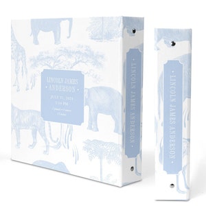 May include: A light blue baby photo album with a white background and a blue and white pattern of animals, including elephants, giraffes, and tigers. The album has a spine with the name "LINCOLN JAMES ANDERSON" printed on it. The front cover has a label with the name "LINCOLN JAMES ANDERSON" and the date "JULY 31, 2024" printed on it.