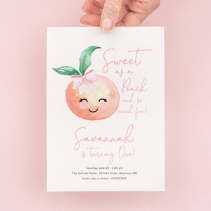 May include: A first birthday party invitation featuring a watercolour illustration of a peach with a pink bow and a smiling face. The text reads "Sweet as a Peach and so much fun! Savannah is turning One!" with details about the party date, time, location, and RSVP information.
