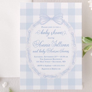 May include: A blue and white gingham baby shower invitation with a blue ribbon and lace design. The invitation reads "Please join us for a baby shower honoring Annie Sullivan and baby Aaron James". The invitation also includes the date, time, location, and RSVP information.