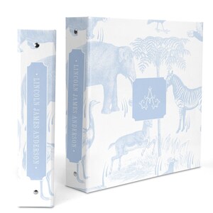May include: A light blue binder with a white background and a pattern of blue animals, including elephants, zebras, and birds. The binder has a spine with the text "LINCOLN JAMES ANDERSON" in a blue rectangle.