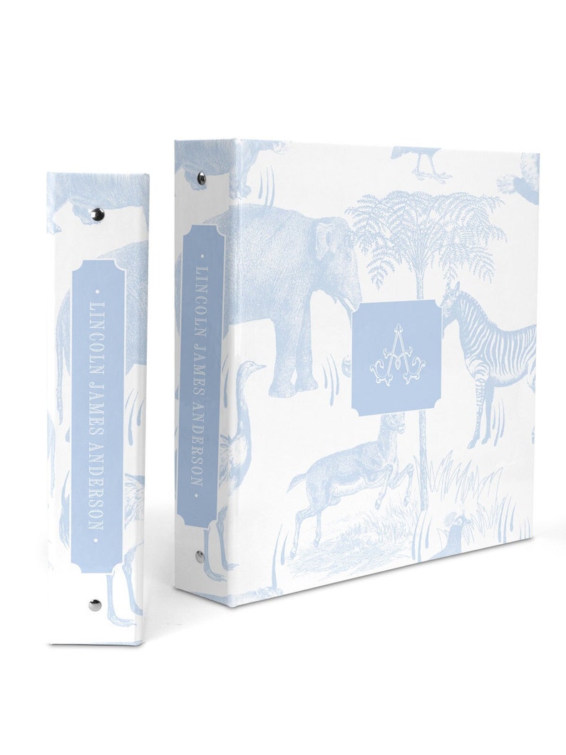 May include: A light blue binder with a white background and a pattern of blue animals, including elephants, zebras, and birds. The binder has a spine with the text "LINCOLN JAMES ANDERSON" in a blue rectangle.
