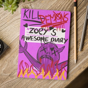 Puede incluir: Un cuaderno morado con el texto "KILL DEMONS" y "Zoey's AWESOME DIARY". La portada presenta un diablo de dibujos animados en llamas. El cuaderno contiene 100 hojas de papel de calidad y mide aproximadamente 14.6 cm.