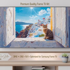 以下が含まれることがあります： テレビ画面に表示されたデジタルアートプリント。白い建物、青い海、窓辺にいるトラ猫を描いた風景画です。「Premium Quality Frame TV Art」の文字が上部にあります。Samsung Frame TV向けに最適化されています。